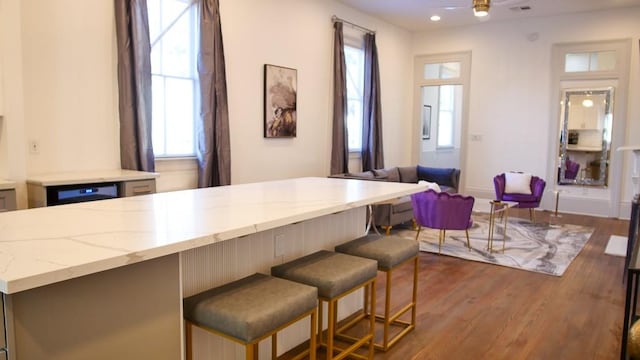 interior space featuring gray cabinets, light stone countertops, and dark hardwood / wood-style flooring