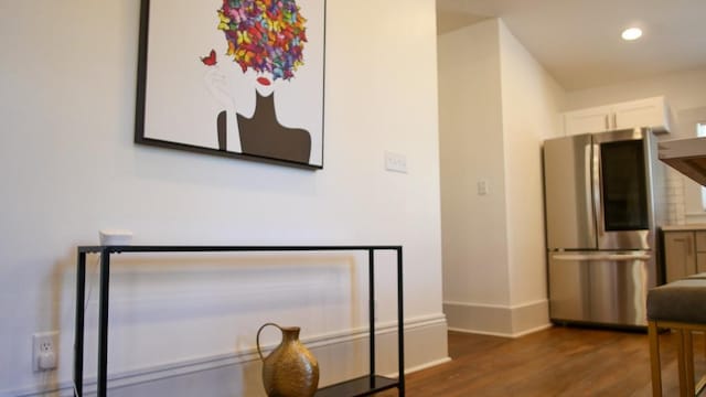 interior space with stainless steel fridge, dark hardwood / wood-style flooring, and white cabinetry