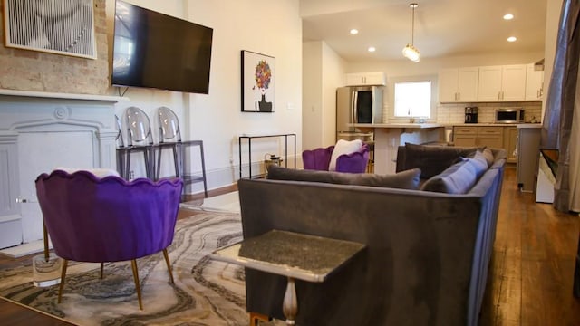 living room with dark hardwood / wood-style floors and sink