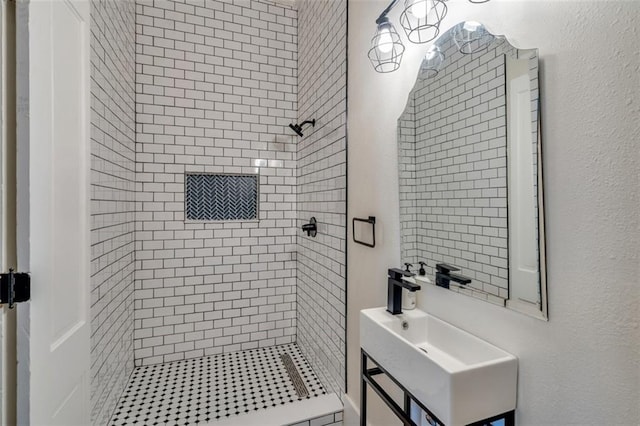 bathroom featuring a tile shower and sink