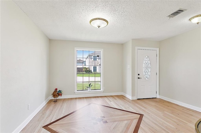 foyer featuring light hardwood / wood-style flooring and a textured ceiling