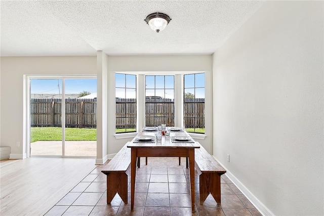 tiled dining space featuring a textured ceiling