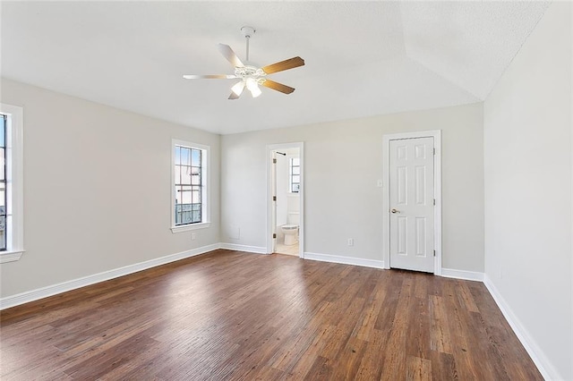 empty room with lofted ceiling, dark wood-type flooring, and ceiling fan