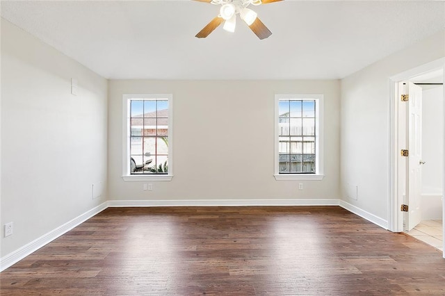 spare room with dark hardwood / wood-style floors and ceiling fan