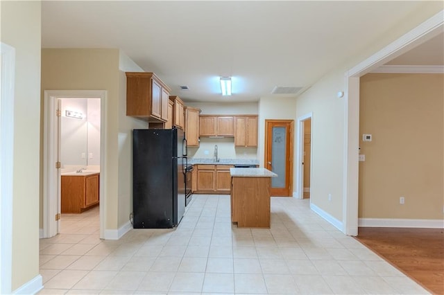 40145 Taylors Trl Unit 204, Slidell, LA 70461 - kitchen with freestanding refrigerator, light countertops, a kitchen island, and light tile patterned floors