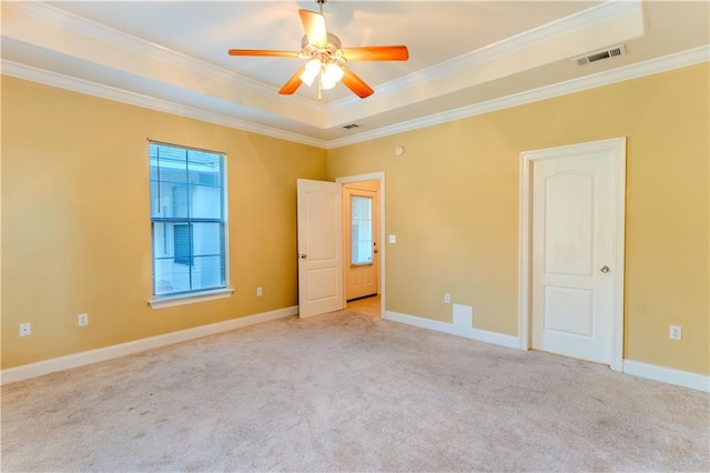 unfurnished room featuring light colored carpet, crown molding, ceiling fan, and a raised ceiling