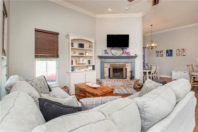 living room featuring hardwood / wood-style flooring, ornamental molding, a fireplace, and a chandelier