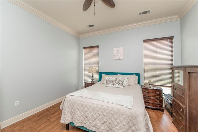 bedroom with multiple windows, crown molding, light hardwood / wood-style floors, and ceiling fan