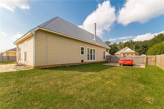 rear view of house featuring a yard and a patio area