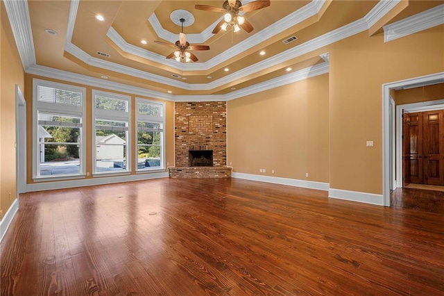 65520 S Hickory Dr, Pearl River, LA 70452 - unfurnished living room featuring wood finished floors, a tray ceiling, a fireplace, a ceiling fan, and baseboards