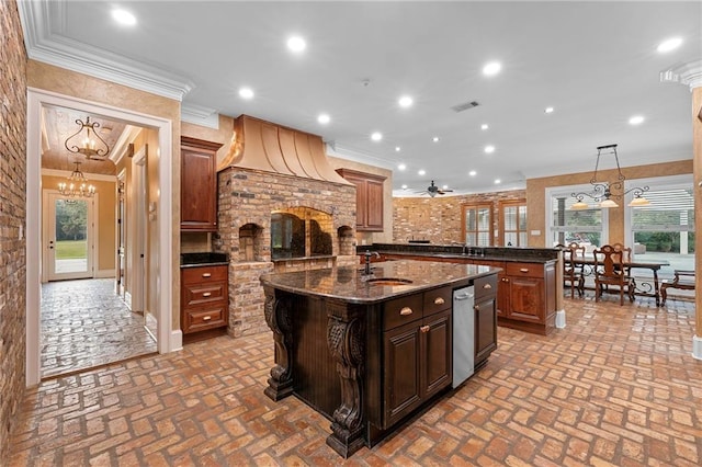 65520 S Hickory Dr, Pearl River, LA 70452 - kitchen featuring an island with sink, a chandelier, ornamental molding, a sink, and brick flooring
