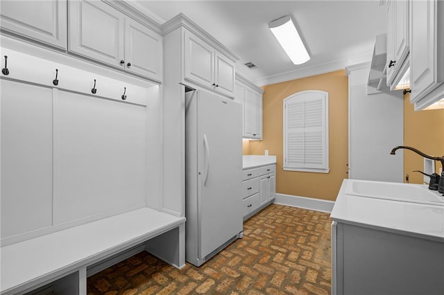 65520 S Hickory Dr, Pearl River, LA 70452 - mudroom featuring brick patterned floors, a sink, crown molding, and baseboards