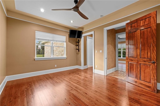 interior space with light hardwood / wood-style floors, multiple windows, and ceiling fan