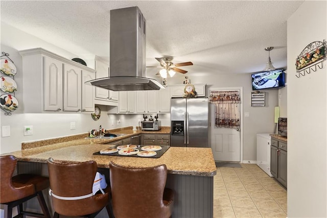 kitchen featuring island exhaust hood, kitchen peninsula, stainless steel fridge with ice dispenser, gray cabinets, and a textured ceiling