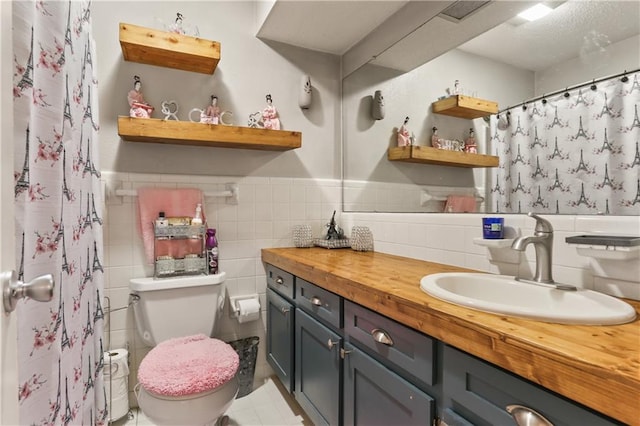 bathroom featuring vanity, tile walls, toilet, and tile patterned flooring