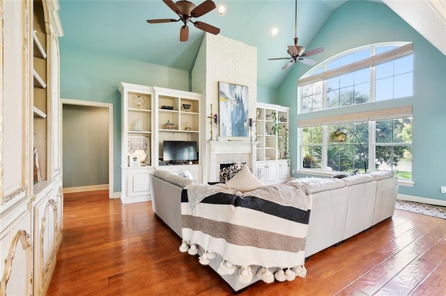 living room featuring wood-type flooring, high vaulted ceiling, and ceiling fan