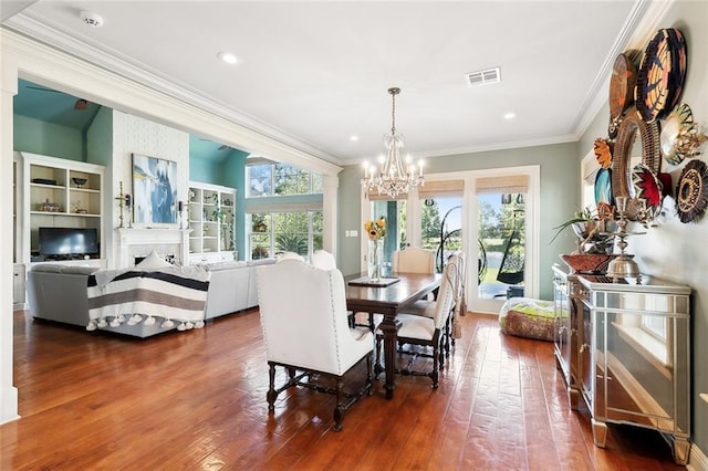 dining area featuring crown molding, dark hardwood / wood-style floors, and a notable chandelier