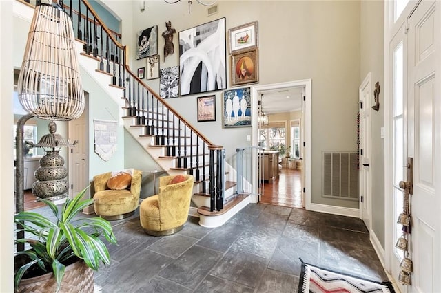 entryway with a towering ceiling and a notable chandelier