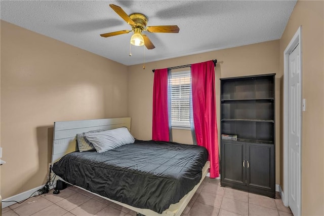 tiled bedroom featuring ceiling fan and a textured ceiling