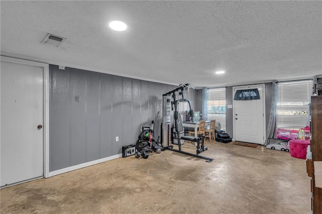 exercise room with concrete floors and a textured ceiling