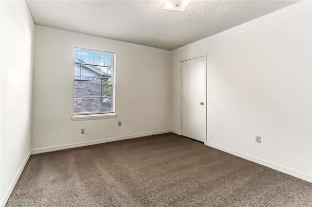 carpeted spare room with a textured ceiling