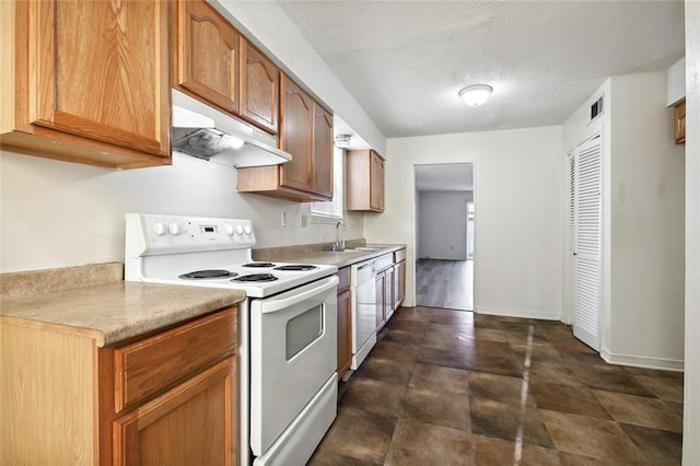 kitchen with a textured ceiling, white appliances, and sink