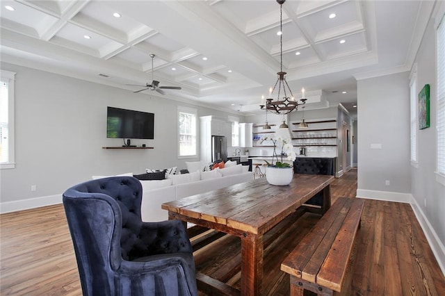 dining area featuring coffered ceiling, ceiling fan with notable chandelier, crown molding, hardwood / wood-style flooring, and beam ceiling