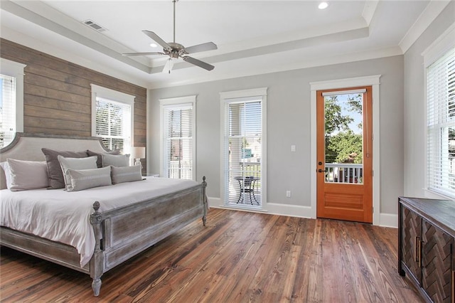 bedroom with a tray ceiling, access to exterior, and dark hardwood / wood-style flooring