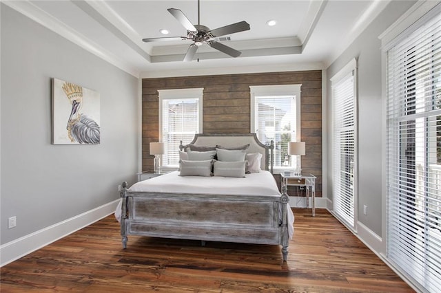 bedroom with ceiling fan, dark wood-type flooring, and a raised ceiling