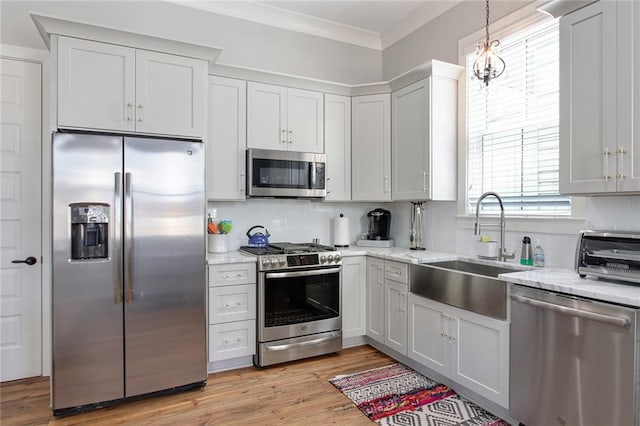 1417-1419 Esplanade Ave, New Orleans, LA 70116 - kitchen with appliances with stainless steel finishes, backsplash, light stone countertops, light wood-style floors, and crown molding