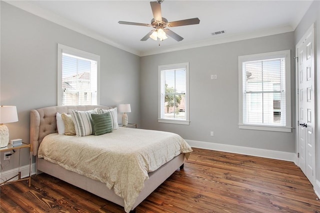 bedroom with crown molding, dark wood-type flooring, and ceiling fan