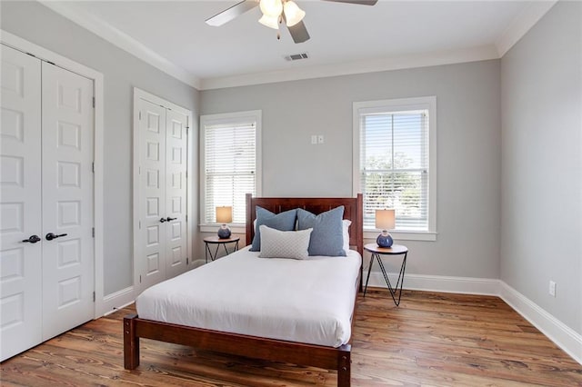 bedroom featuring crown molding, multiple windows, and hardwood / wood-style floors