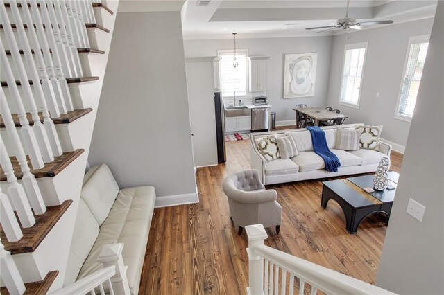 1417-1419 Esplanade Ave, New Orleans, LA 70116 - living room with stairway, ceiling fan, light wood-style floors, and crown molding