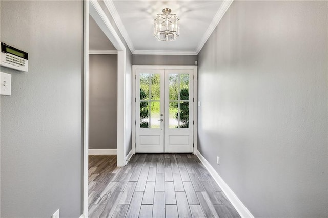 doorway with hardwood / wood-style floors, ornamental molding, french doors, and an inviting chandelier