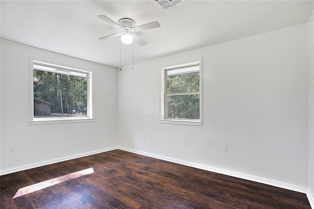 empty room with ceiling fan, a wealth of natural light, and hardwood / wood-style floors