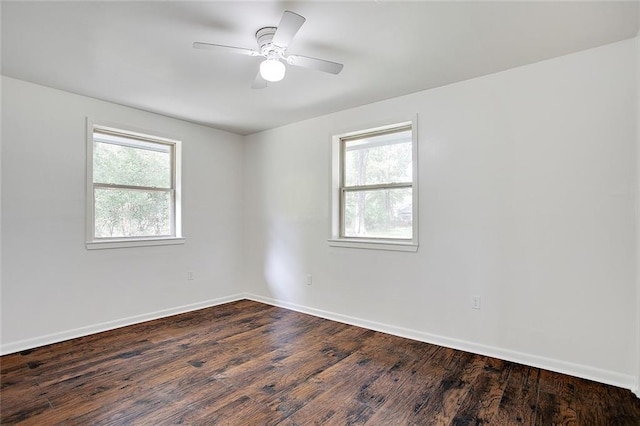 empty room with dark hardwood / wood-style flooring, ceiling fan, and a wealth of natural light