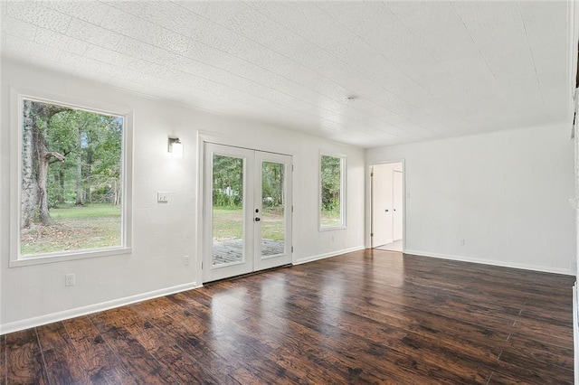 empty room featuring french doors and dark hardwood / wood-style flooring