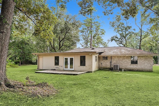 back of house featuring a wooden deck, french doors, and a lawn