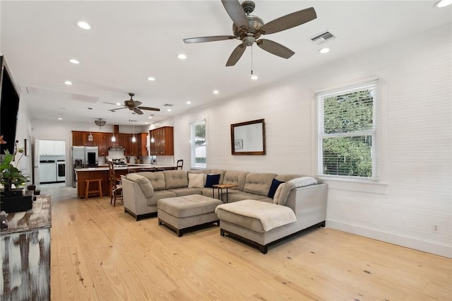 living room featuring light hardwood / wood-style floors and ceiling fan