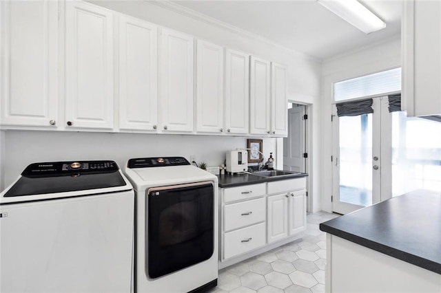 laundry room with sink, ornamental molding, cabinets, and washing machine and clothes dryer