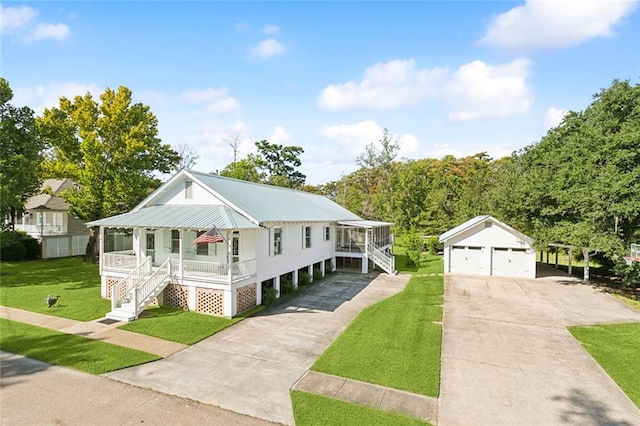 view of front of house featuring covered porch, an outdoor structure, a garage, and a front lawn