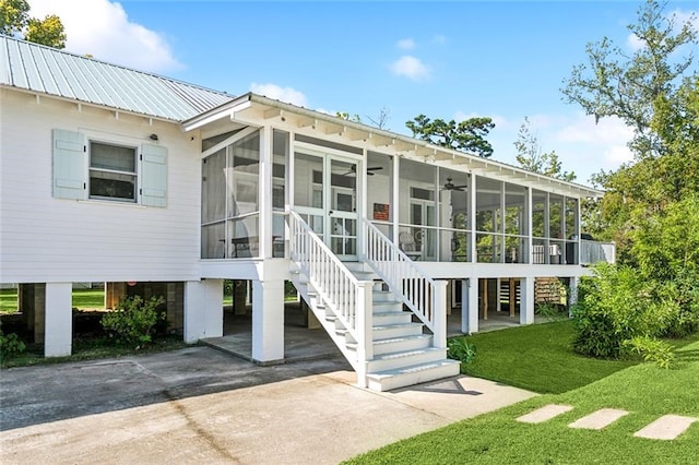 back of house featuring a lawn and a sunroom