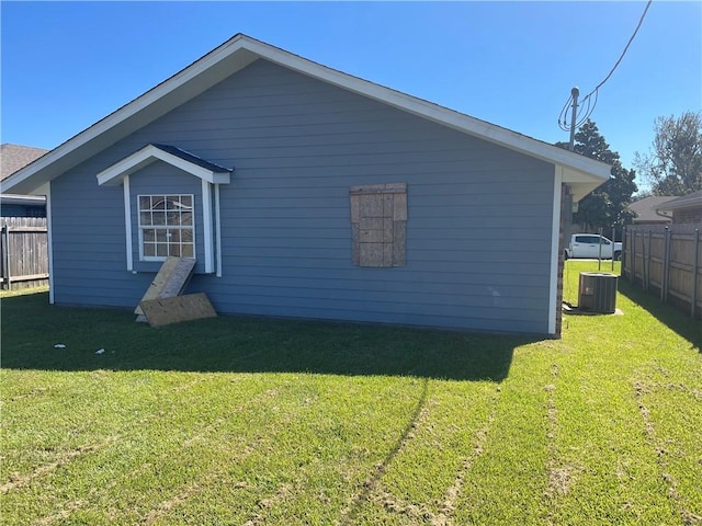 rear view of property featuring central AC and a lawn