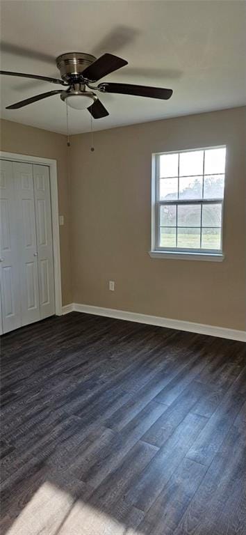 unfurnished bedroom with dark wood-type flooring, a closet, and ceiling fan