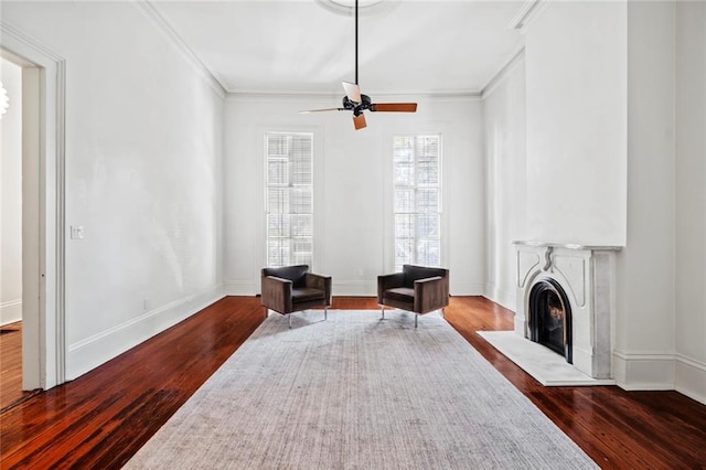 sitting room with hardwood / wood-style floors, crown molding, and ceiling fan