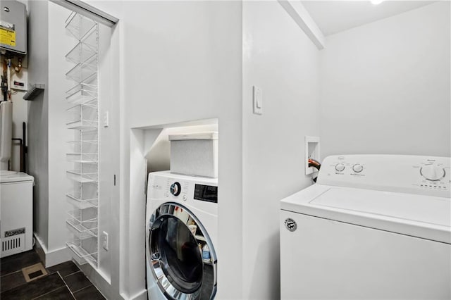 laundry room with independent washer and dryer and dark tile patterned floors