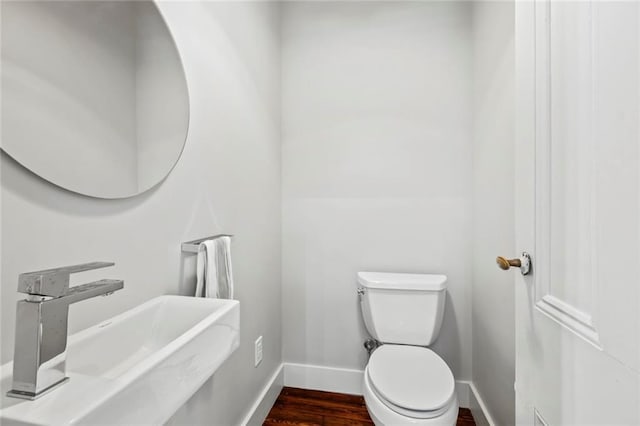 bathroom featuring sink, hardwood / wood-style flooring, and toilet