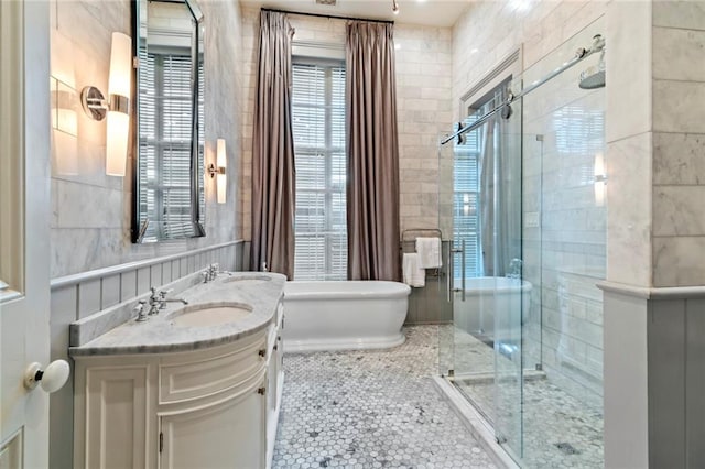 bathroom featuring tile walls, toilet, a shower with shower door, vanity, and tile patterned floors