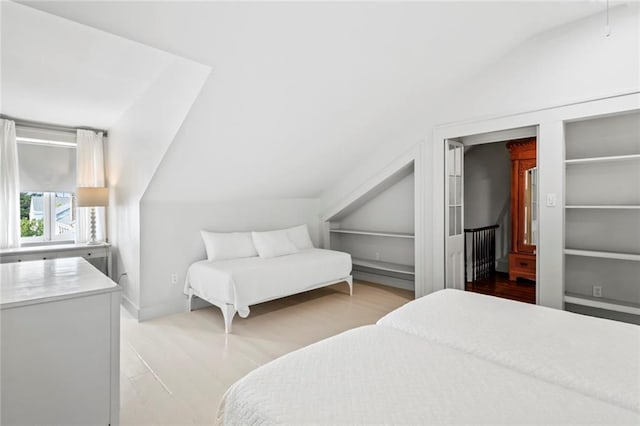 bedroom with light hardwood / wood-style flooring and vaulted ceiling