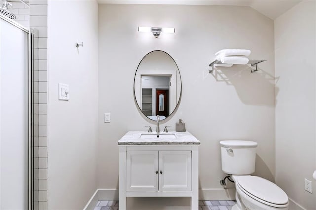 bathroom with a shower with door, vanity, and toilet